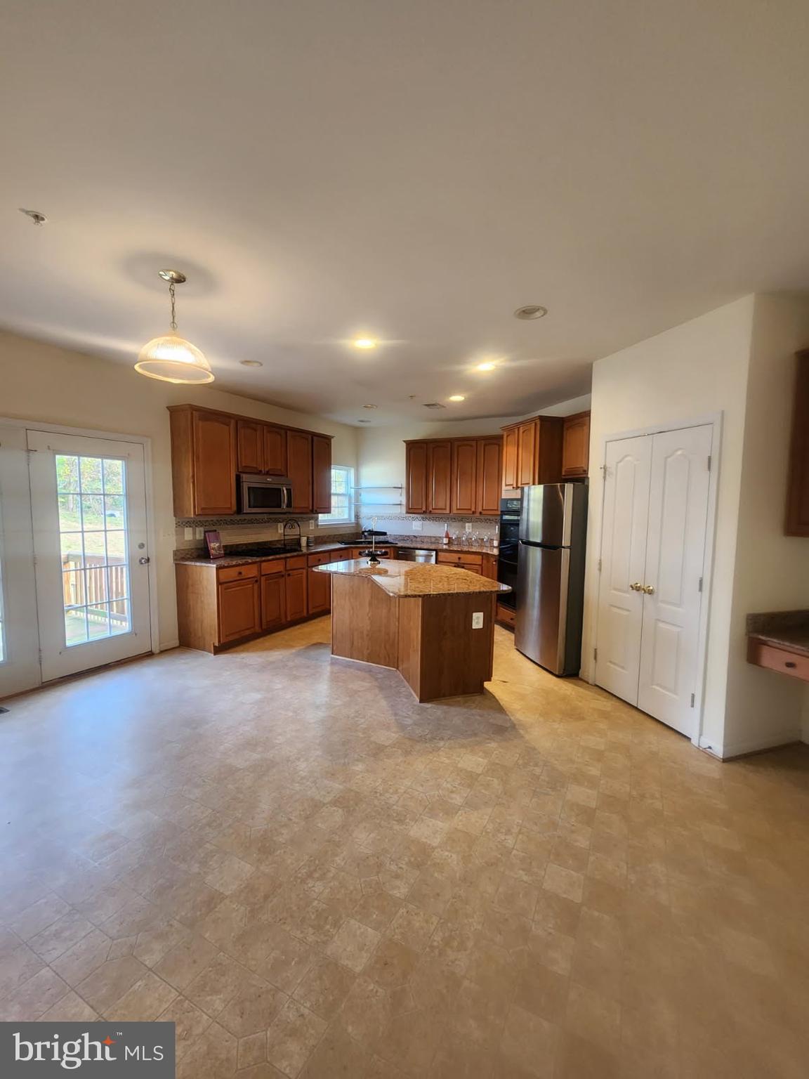 10208 Rolling Green Way Fort Washington, MD 20744 - Photo 5 of 14 a large kitchen with stainless steel appliances granite countertop a refrigerator and a stove top oven