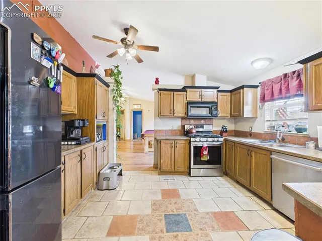 a kitchen with stainless steel appliances granite countertop a stove a sink and a refrigerator