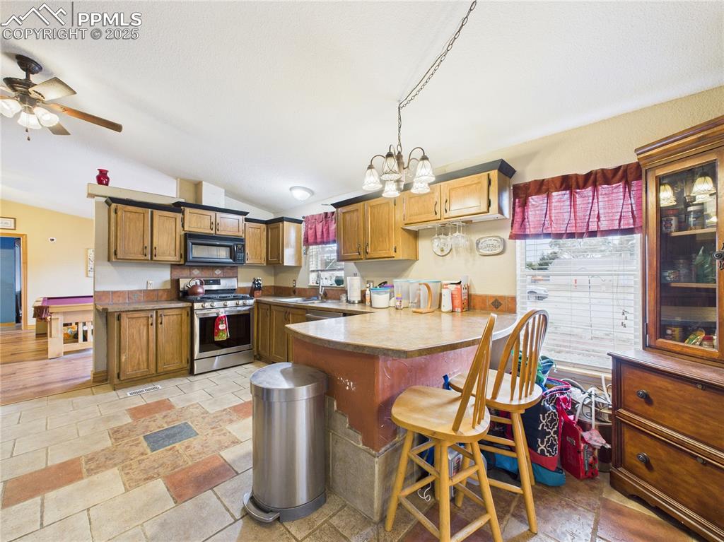 206 Lucille Street Avondale, CO 81022 - Photo 16 of 36 a kitchen with a sink a stove and chairs