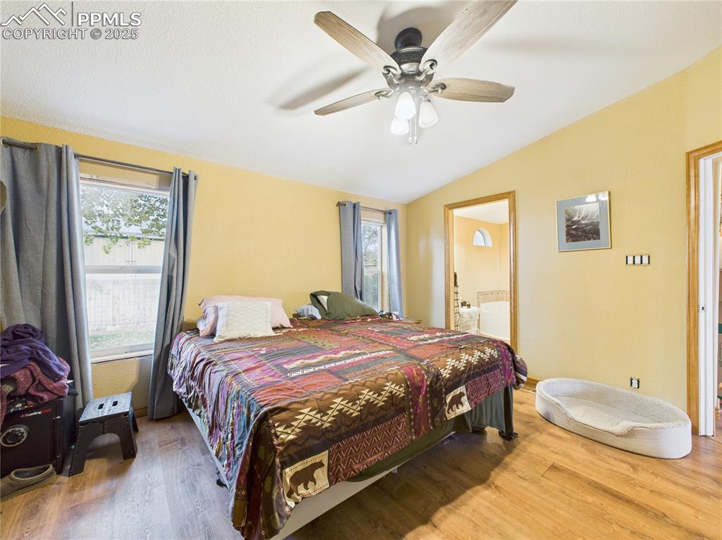 206 Lucille Street Avondale, CO 81022 - Photo 21 of 36 a bedroom with a bed and a chandelier