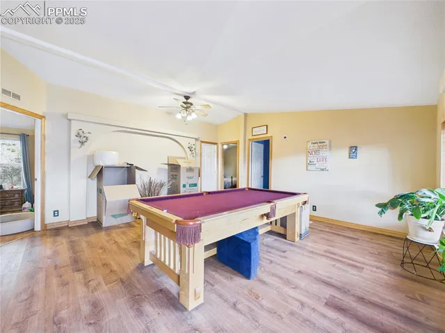 a room with pool table and wooden floor