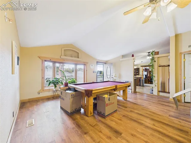 a living room with furniture a wooden floor and a large window