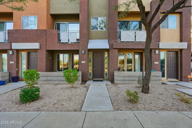 a front view of a brick house with a yard and plants