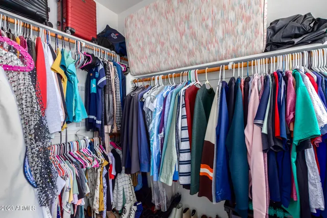 a view of walk in closet with clothes and shoes