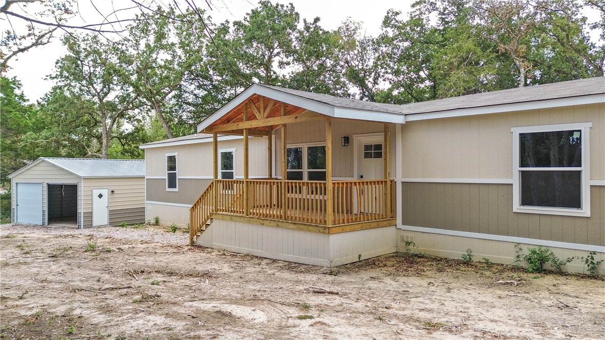 a view of a house with a small yard and wooden fence