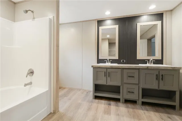 a spacious bathroom with a shower a sink and a mirror