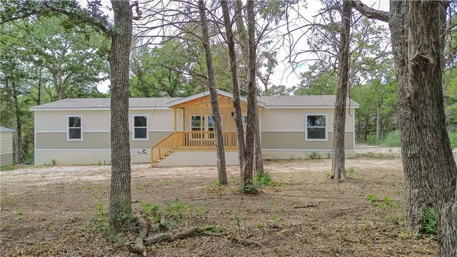 a view of a house with backyard and a tree