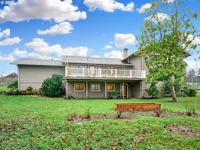 a front view of a house with a yard and potted plants