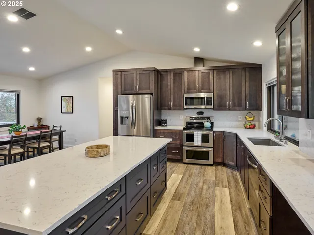 a kitchen with kitchen island white cabinets and stainless steel appliances
