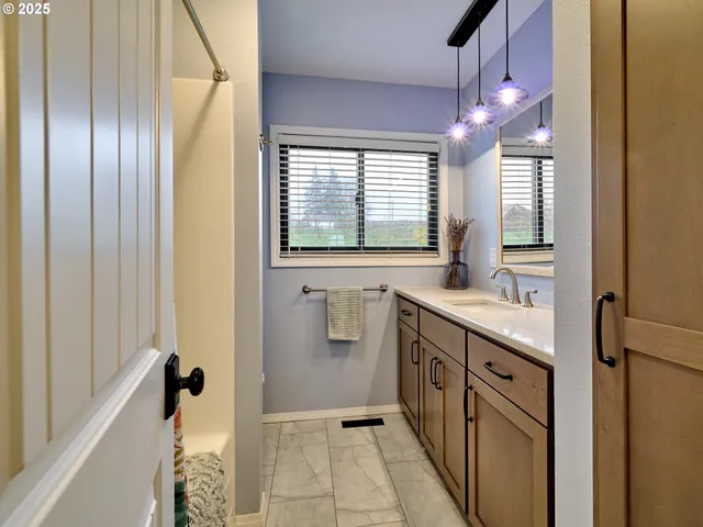 a bathroom with a double vanity sink and mirror with bathtub