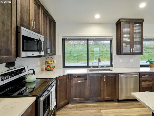 a kitchen with stainless steel appliances a stove sink microwave and cabinets