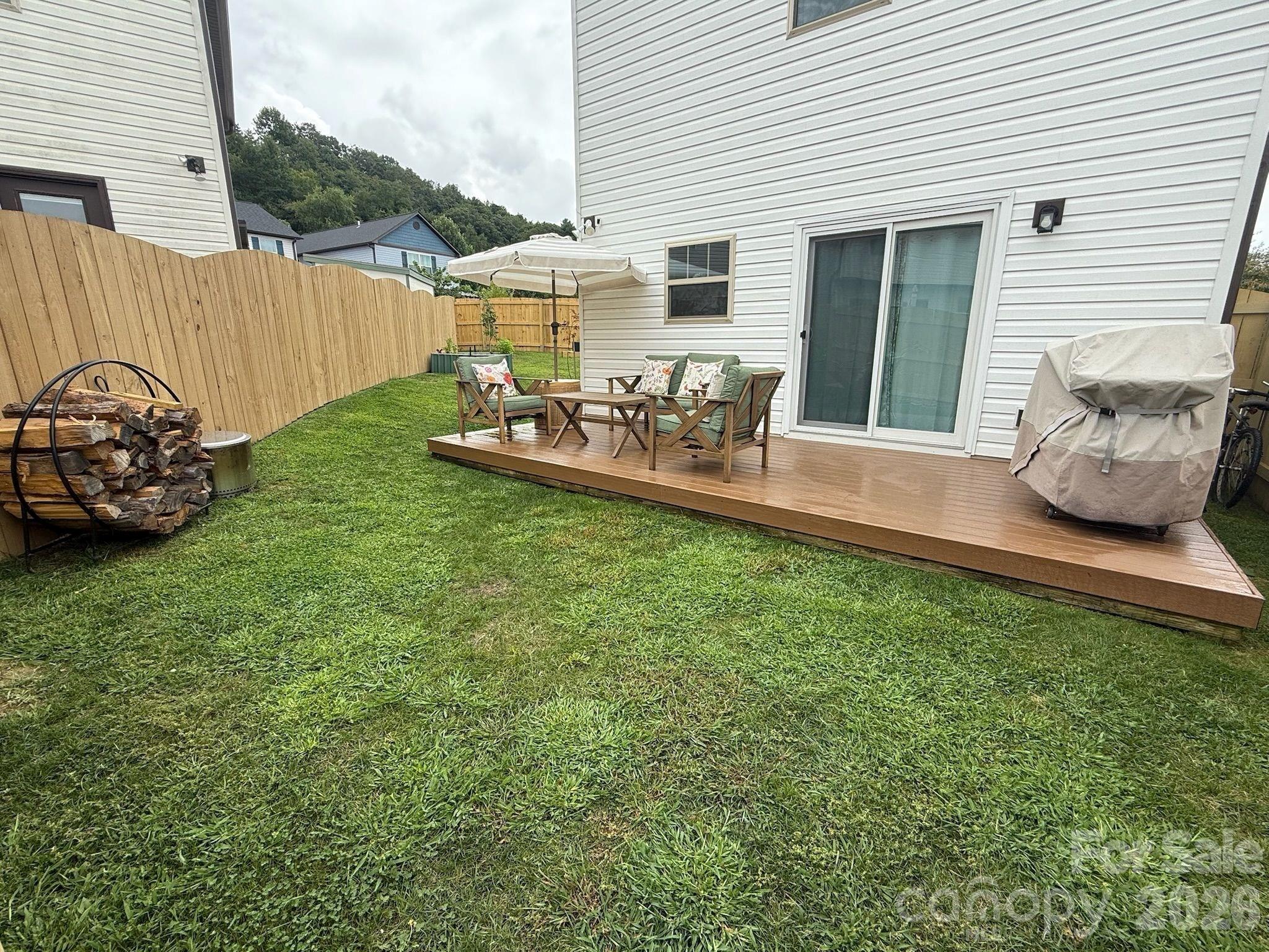 526 Cardwell Lane Fletcher, NC 28732 - Photo 36 of 37 a view of a backyard with table and chairs potted plants and a wooden deck