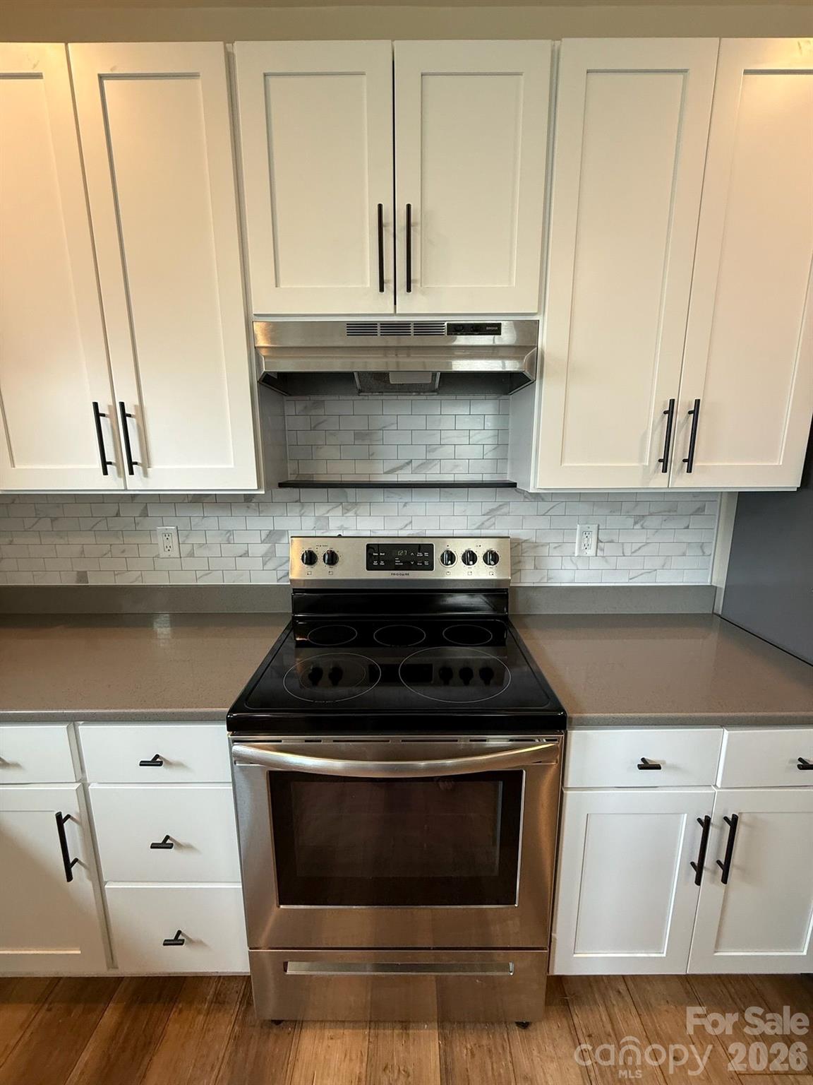 526 Cardwell Lane Fletcher, NC 28732 - Photo 5 of 37 a kitchen with granite countertop white cabinets and black appliances