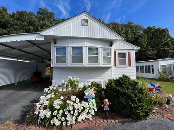 10 St James Circle Hudson, MA 01749 - Photo 2 of 14 a front view of a house with a yard with yellow lighting