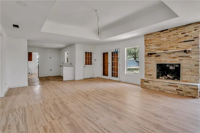 an empty room with windows and fireplace