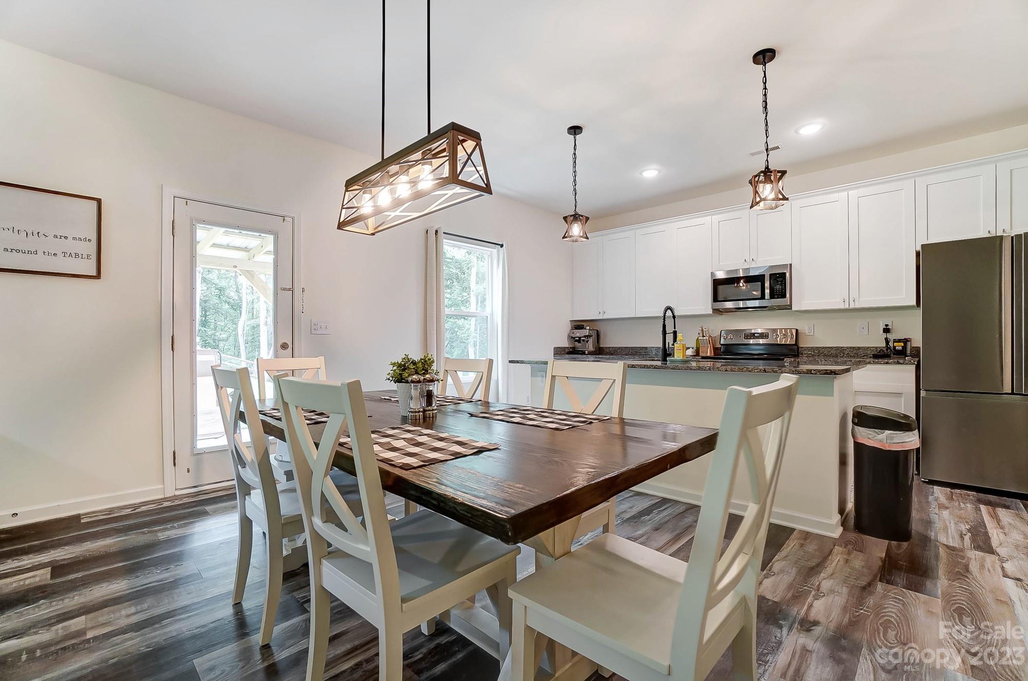 164 Mill Creek Road Iron Station, NC 28080 - Photo 11 of 48 a view of a dining room with furniture a chandelier and wooden floor