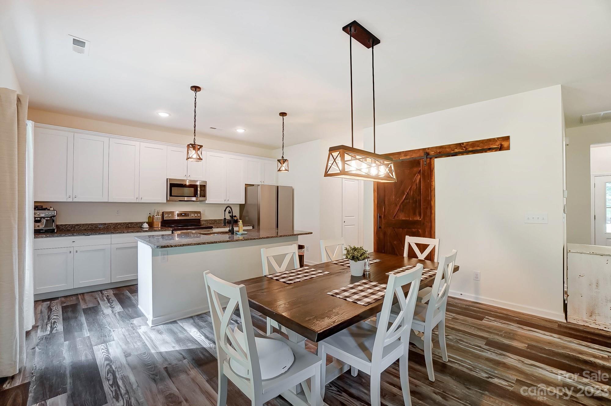 164 Mill Creek Road Iron Station, NC 28080 - Photo 12 of 48 a kitchen with stainless steel appliances a kitchen island a stove a table and chairs