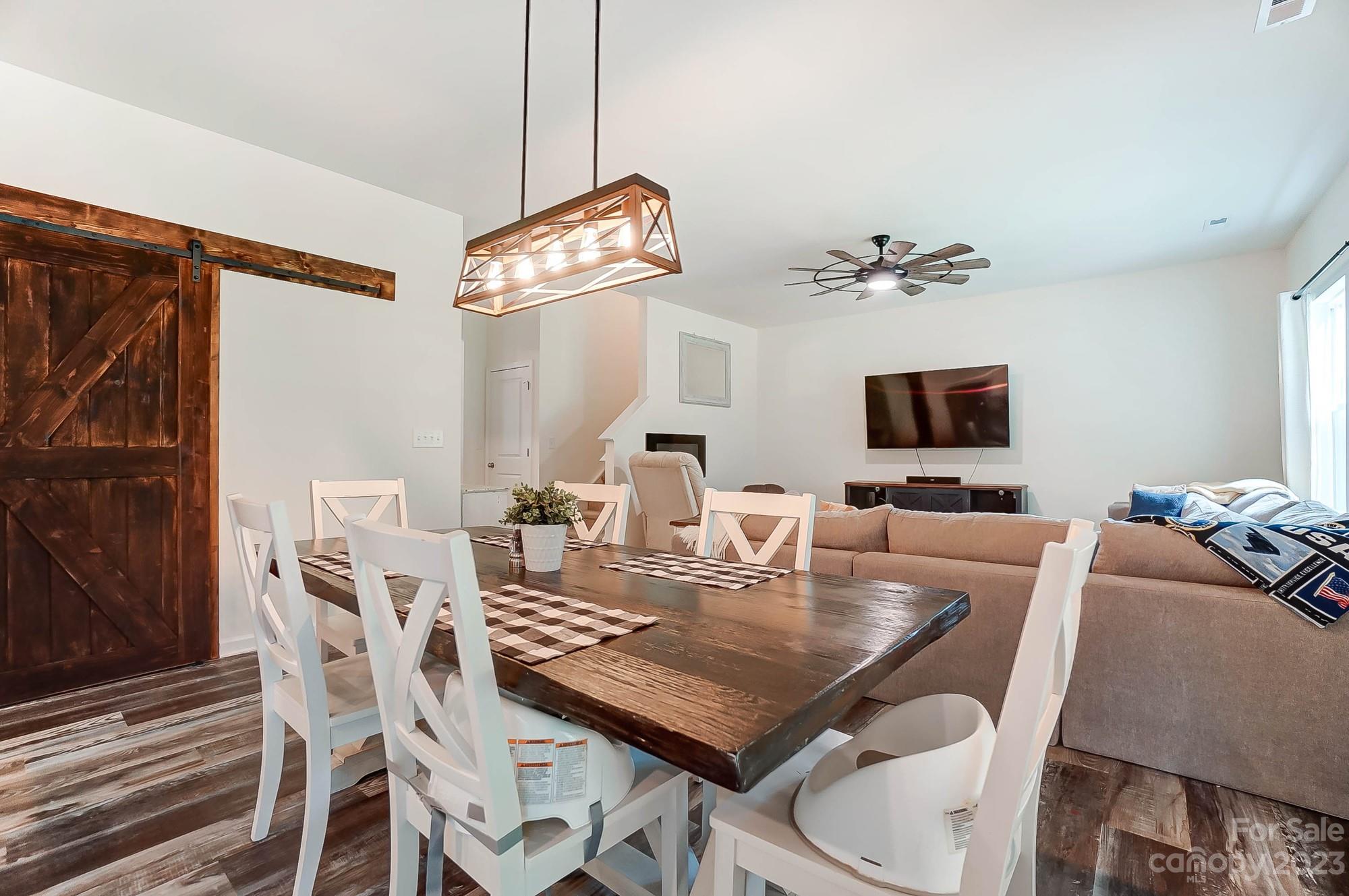 164 Mill Creek Road Iron Station, NC 28080 - Photo 13 of 48 a view of a dining room with furniture a chandelier and wooden floor