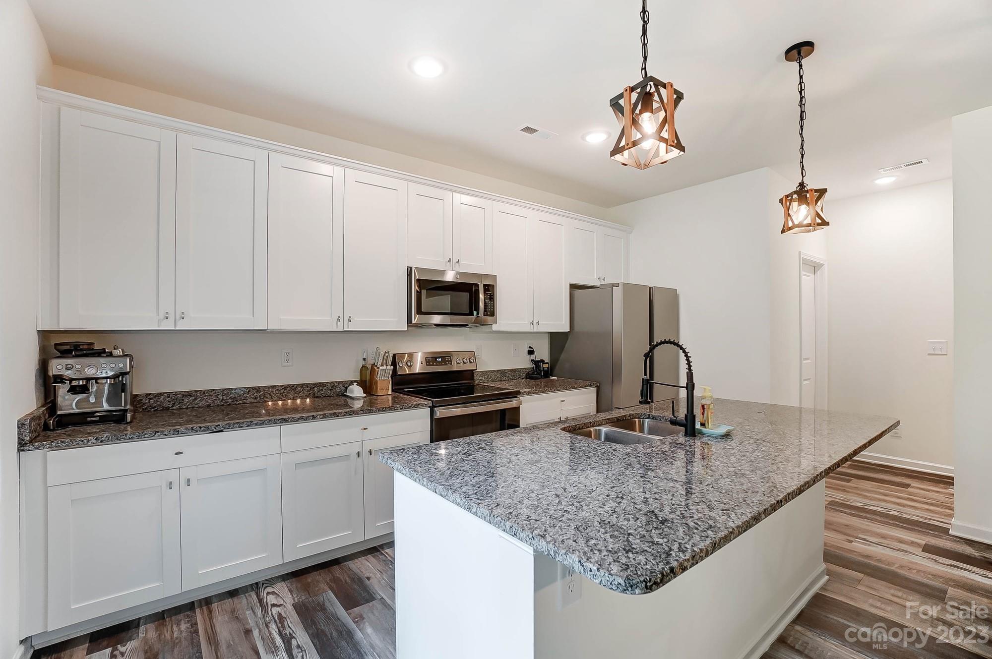 164 Mill Creek Road Iron Station, NC 28080 - Photo 14 of 48 a kitchen with stainless steel appliances granite countertop a sink refrigerator and microwave