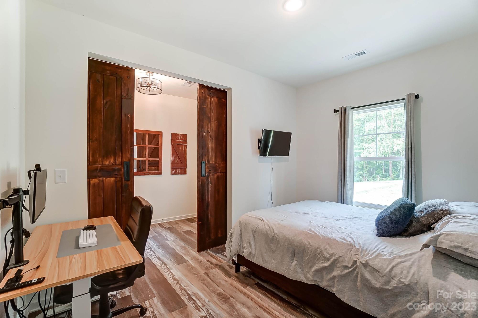 164 Mill Creek Road Iron Station, NC 28080 - Photo 20 of 48 a bedroom with a bed wooden floor and a window