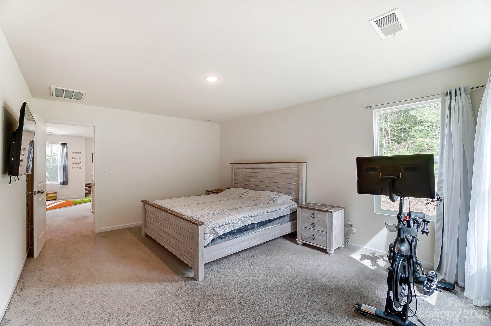 164 Mill Creek Road Iron Station, NC 28080 - Photo 29 of 48 a bedroom with a bed and a flat tv screen on the dresser