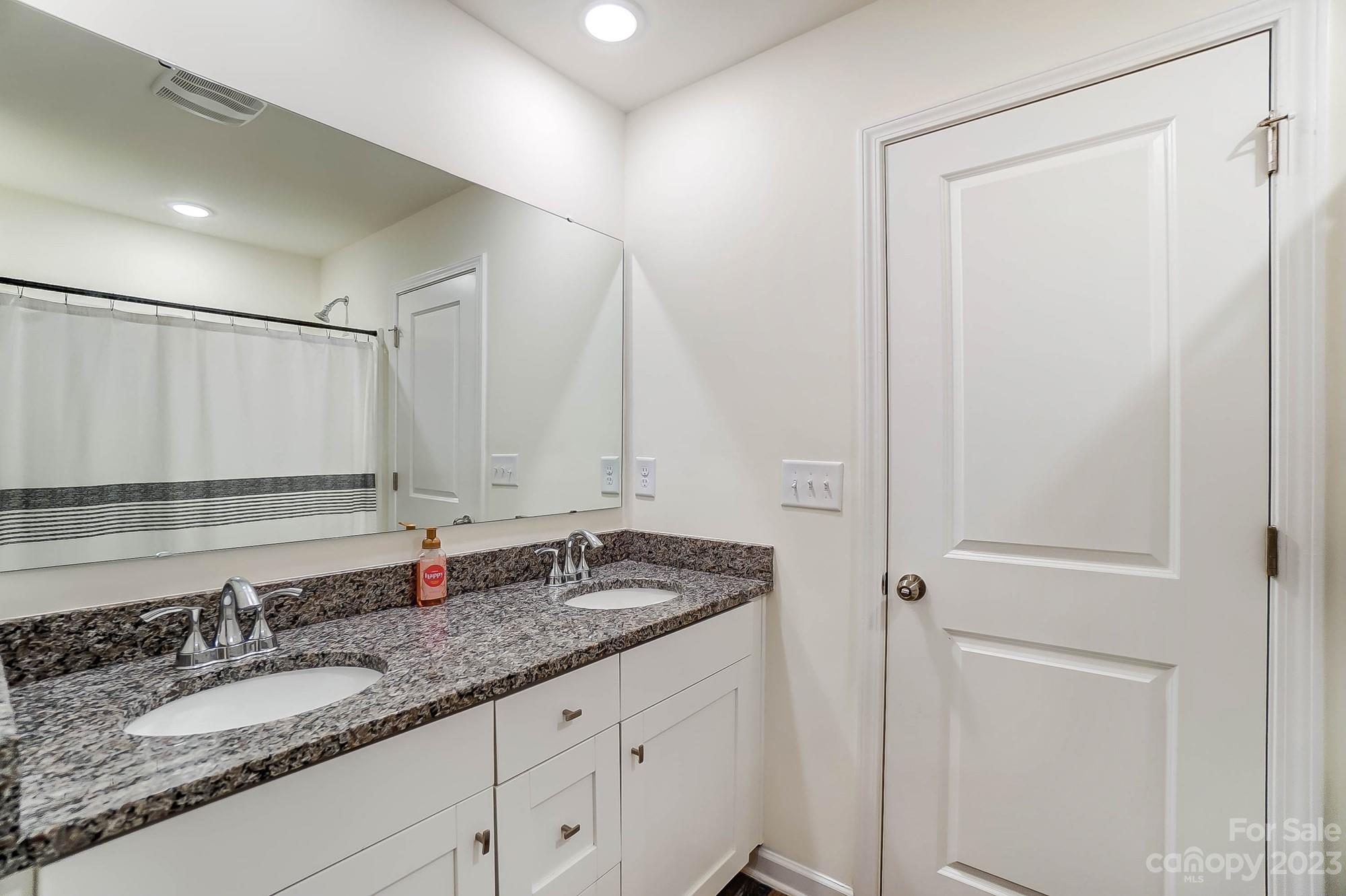 164 Mill Creek Road Iron Station, NC 28080 - Photo 34 of 48 a bathroom with a granite countertop sink and a mirror