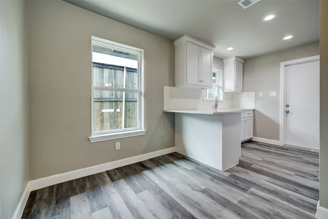 a room with a sink cabinets and wooden floor