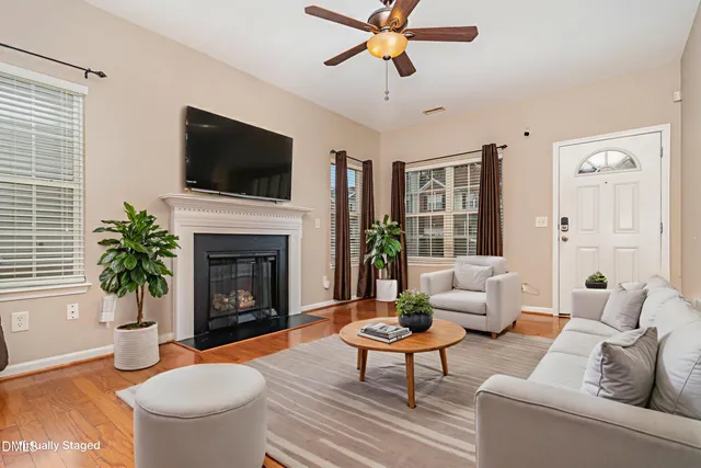 a living room with furniture a flat screen tv and a fireplace