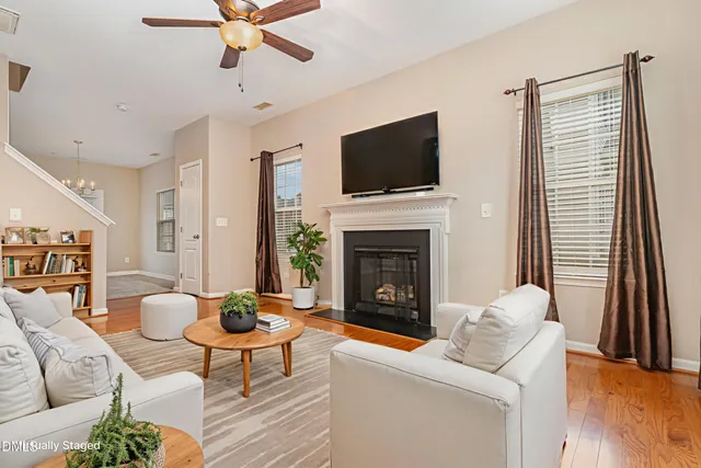 a living room with furniture a flat screen tv and a fireplace