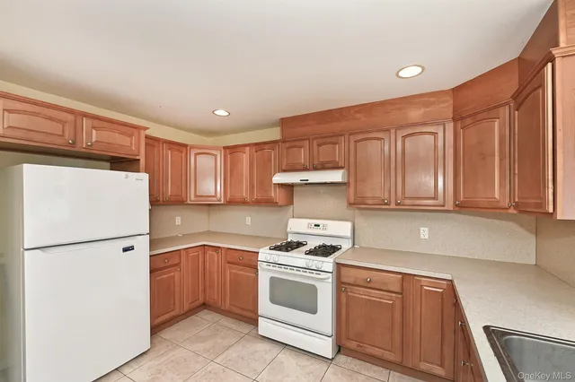 a kitchen with a refrigerator sink and cabinets