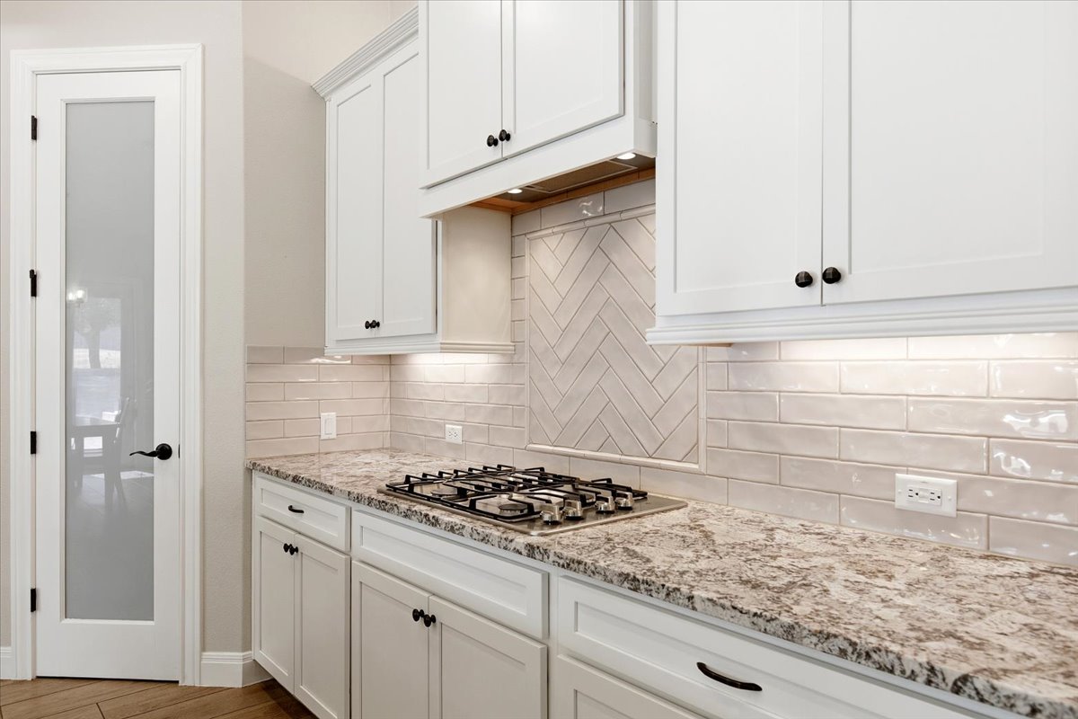 304 Morning Ridge Georgetown, TX 78628 - Photo 13 of 31 Kitchen featuring white cabinetry, light stone countertops, and decorative backsplash
