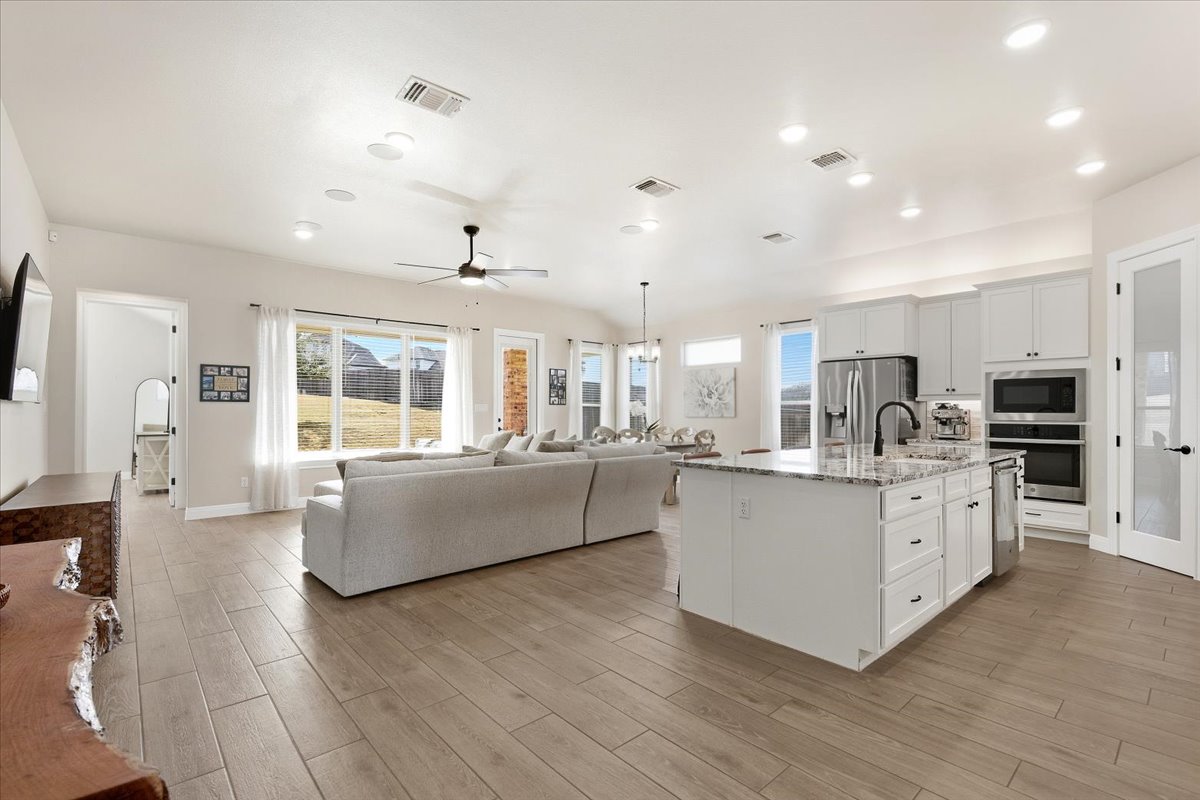 304 Morning Ridge Georgetown, TX 78628 - Photo 31 of 31 Kitchen featuring open floor plan, white cabinetry, stainless steel appliances, light stone counters, and an island with sink