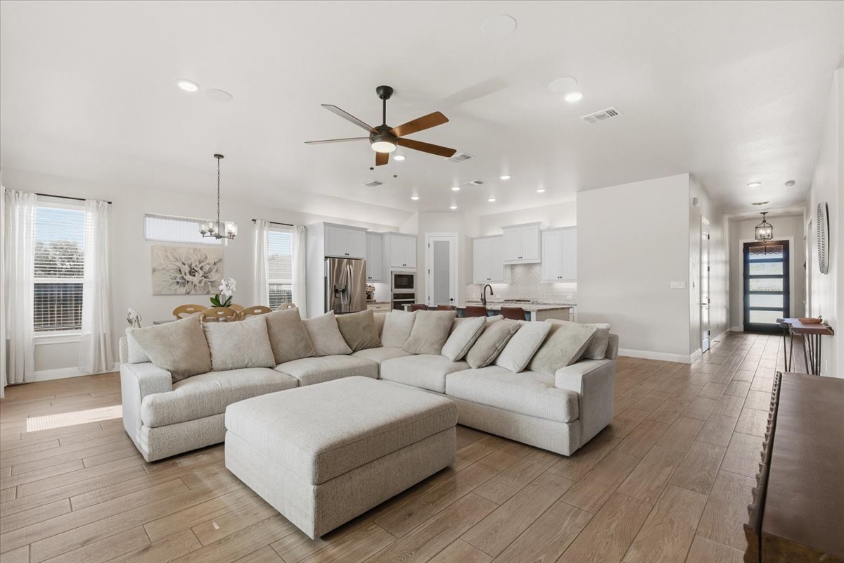 304 Morning Ridge Georgetown, TX 78628 - Photo 15 of 31 Living area with ceiling fan, light wood-style flooring, and a chandelier