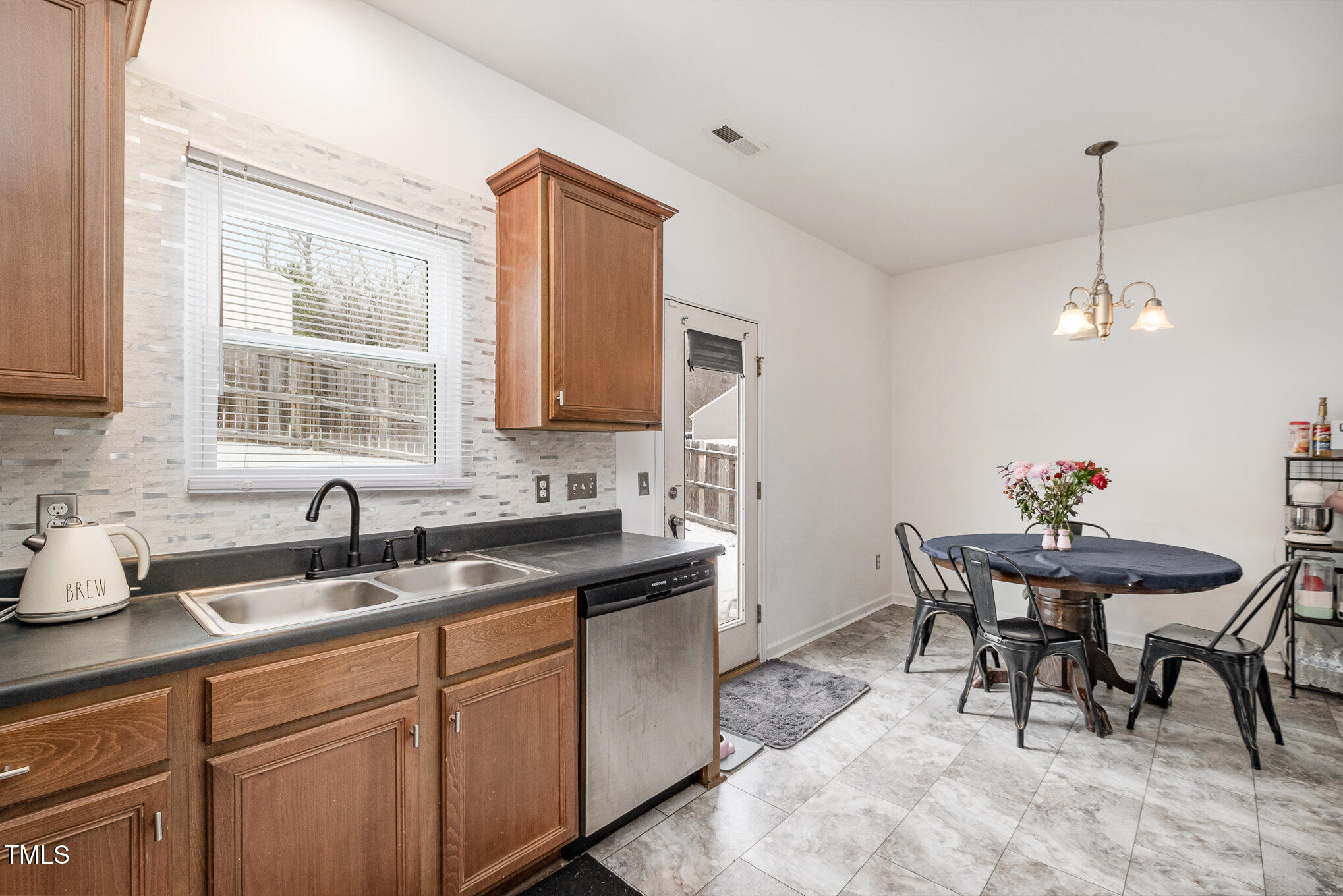5627 Quitman Trail Raleigh, NC 27610 - Photo 7 of 26 a kitchen with stainless steel appliances granite countertop a sink a stove a dining table and chairs
