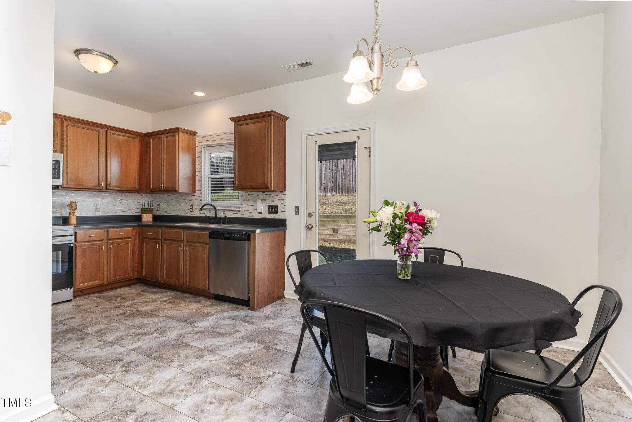 5627 Quitman Trail Raleigh, NC 27610 - Photo 8 of 26 a kitchen with a table chairs a sink and cabinets