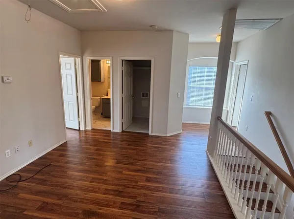 a view of a hallway with wooden floor and stairs