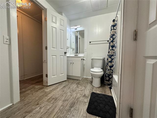 468 Rio Grande Road South Fork, CO 81154 - Photo 26 of 34 Full bathroom with vanity, light wood-style floors, shower / bath combo, and wood walls