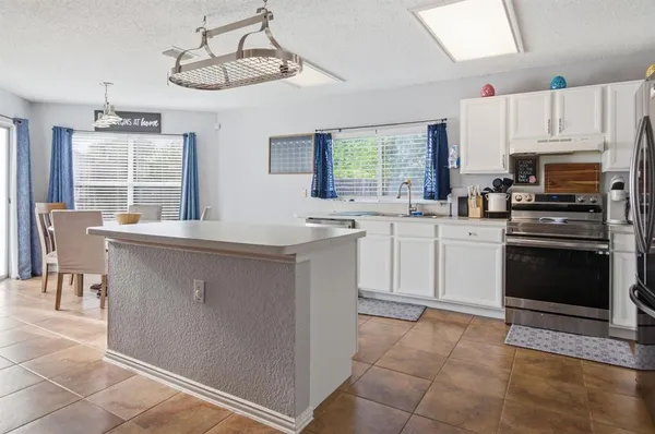 a kitchen with a sink stove top oven and cabinets