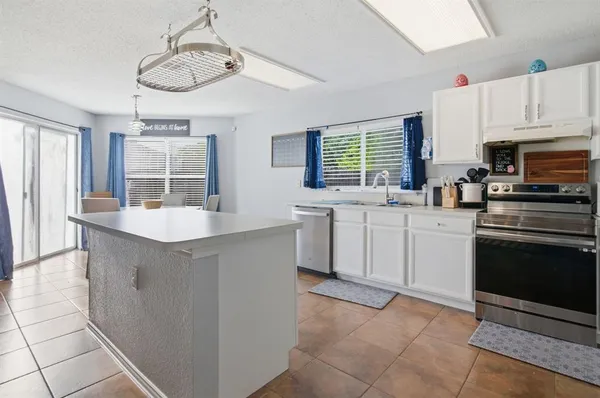 a kitchen with stainless steel appliances a sink stove and cabinets