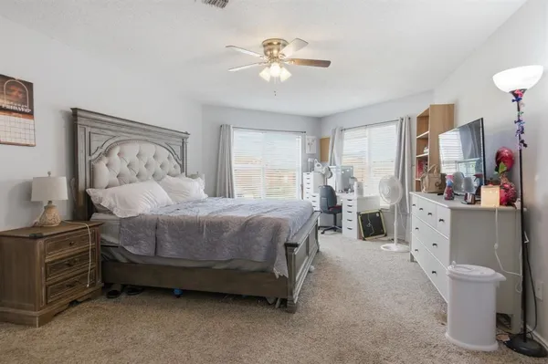 a spacious bedroom with a bed and a chandelier