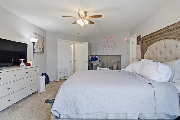 a bedroom with a large bed and a flat tv screen on dresser