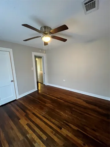 a view of empty room with window and wooden floor