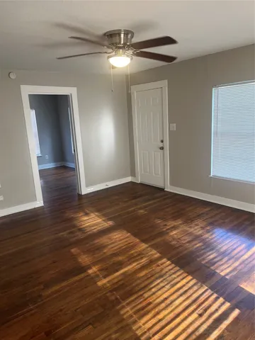 a view of empty room with wooden floor