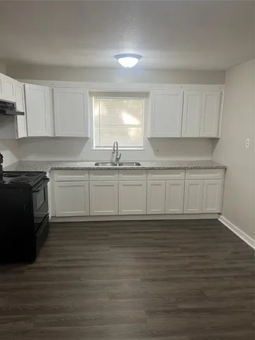 a kitchen with wooden cabinets sink and cabinets