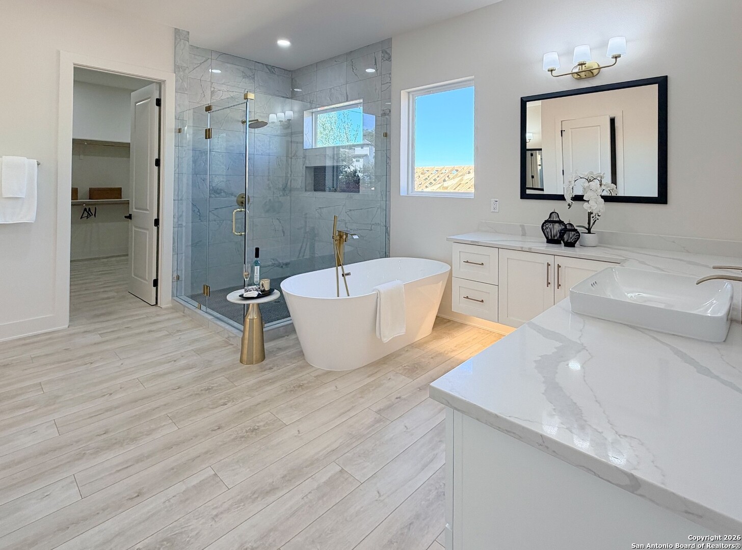 11010 Nina Ridge San Antonio, TX 78255 - Photo 30 of 44 a bathroom with a tub a sink and a large mirror