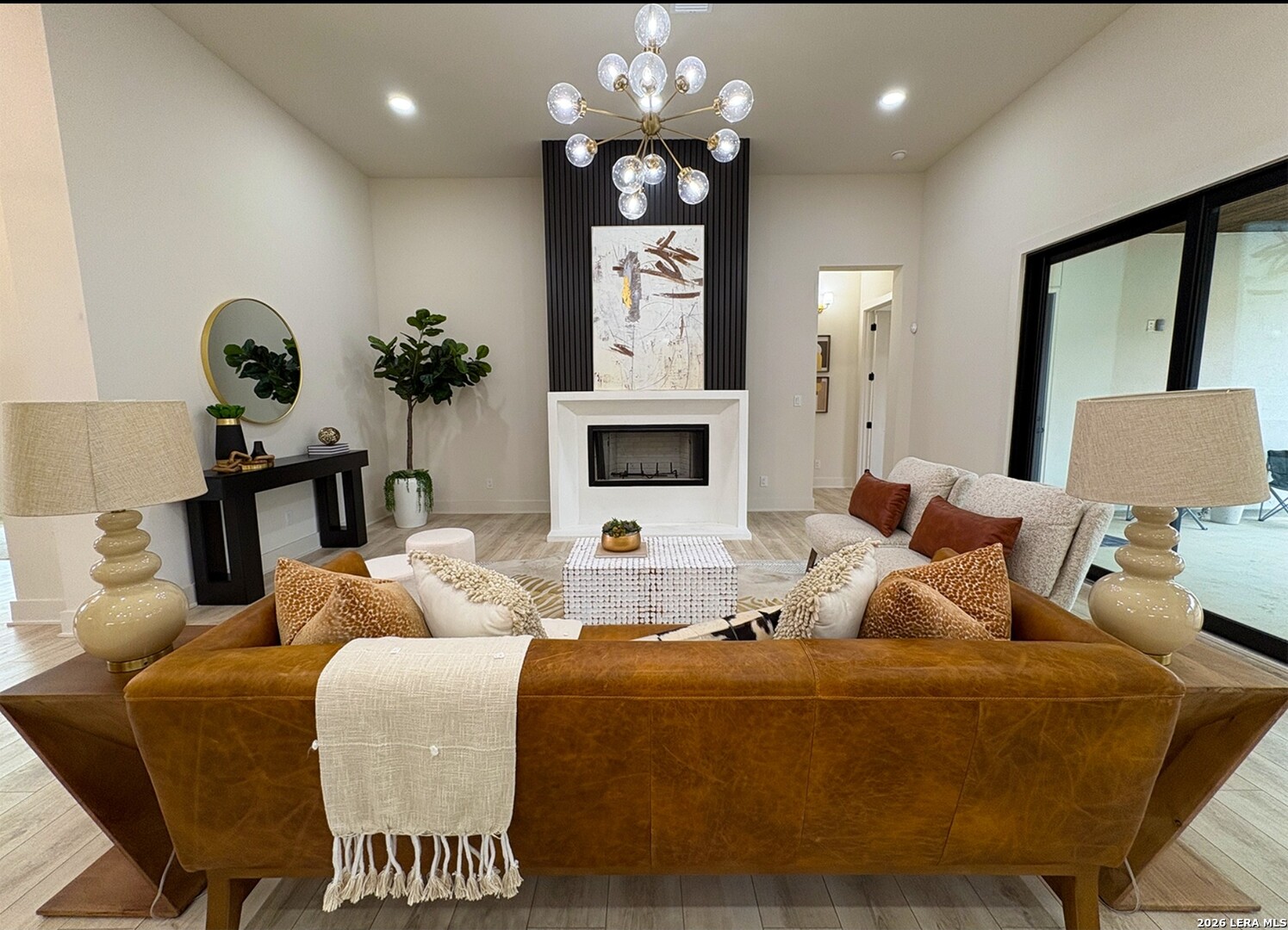11010 Nina Ridge San Antonio, TX 78255 - Photo 10 of 44 a living room with furniture a fireplace and a chandelier