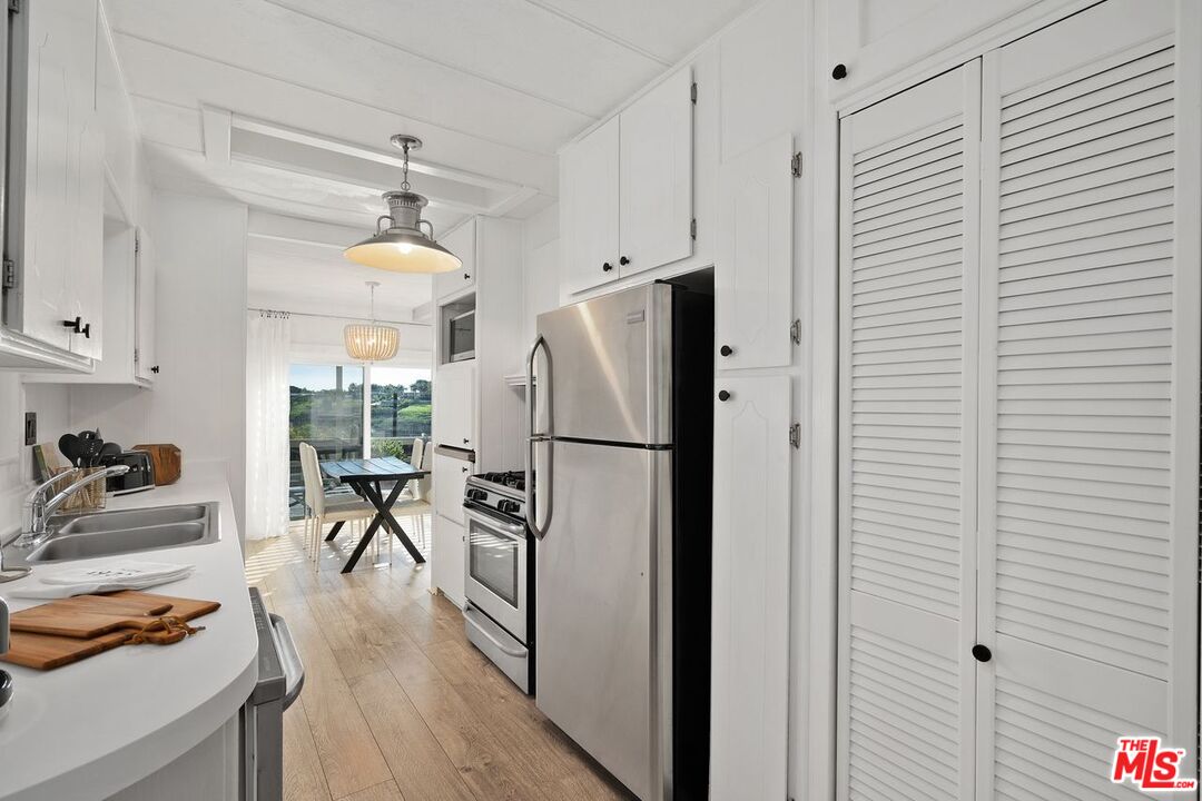 29500 Heathercliff Road, Unit SPC 103 Malibu, CA 90265 - Photo 5 of 15 a kitchen with sink a refrigerator and wooden floor