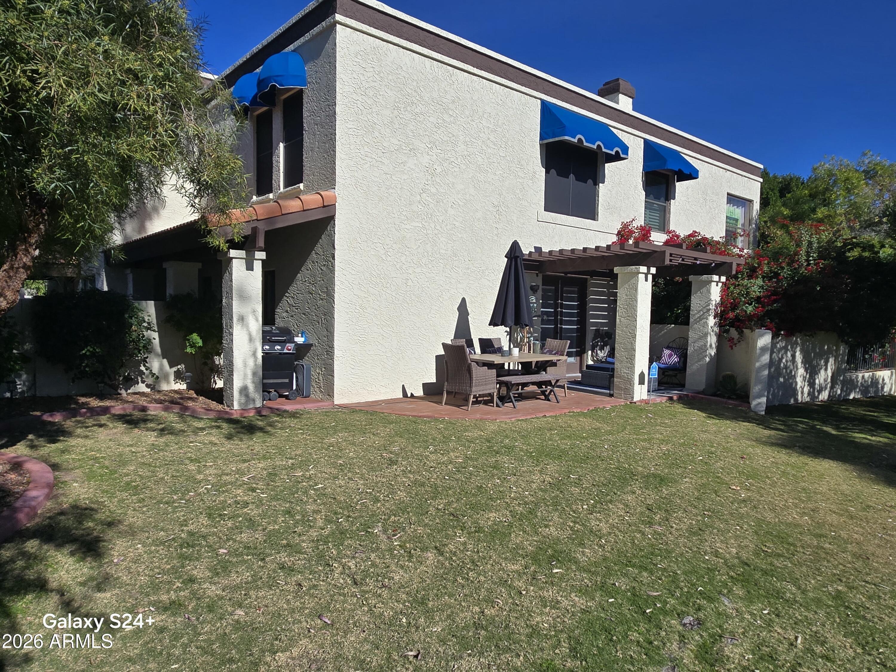 a view of a house with patio and a yard