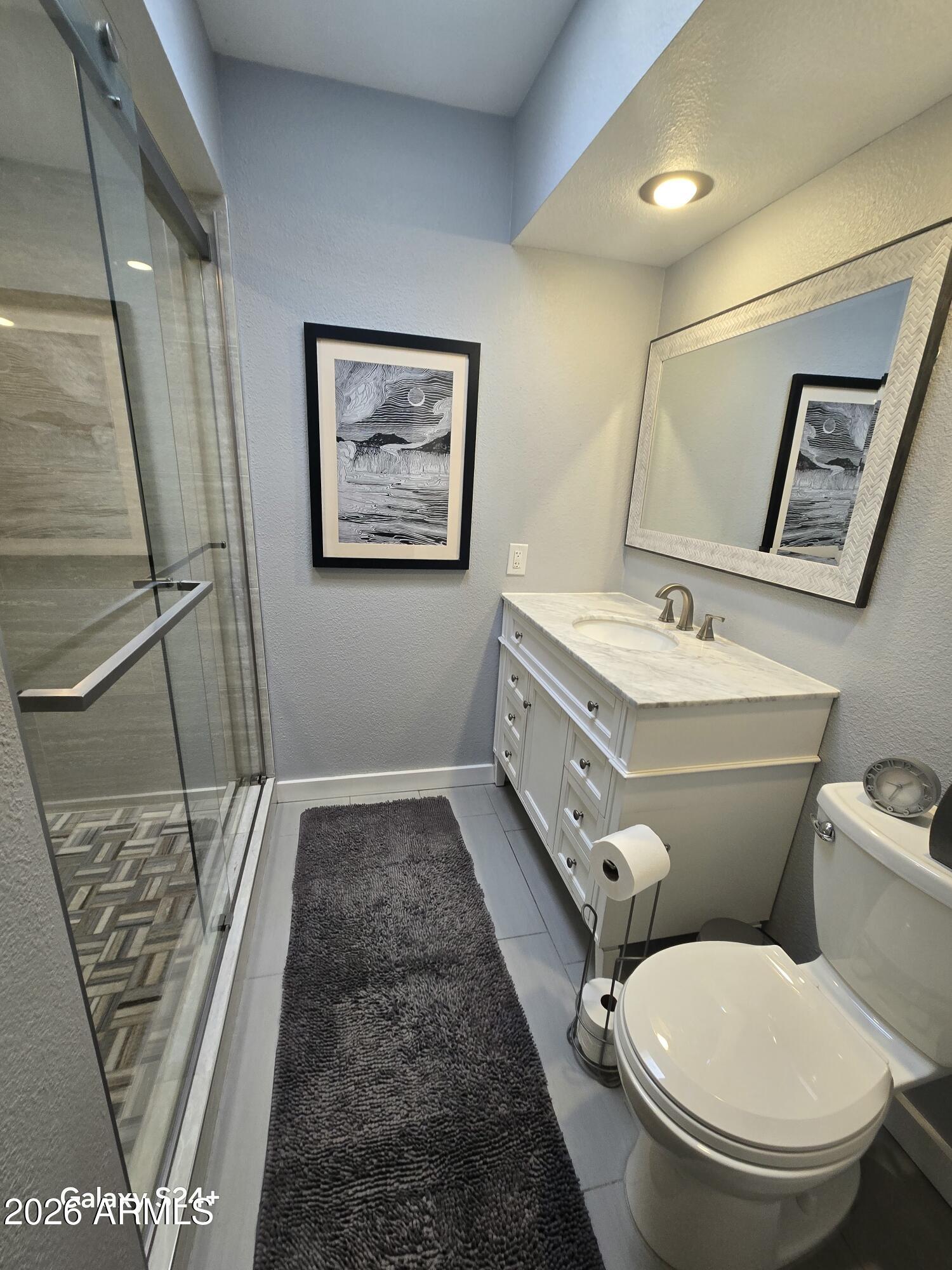 8611 South 48th Street, Unit 2 Phoenix, AZ 85044 - Photo 8 of 12 a bathroom with a toilet sink and mirror