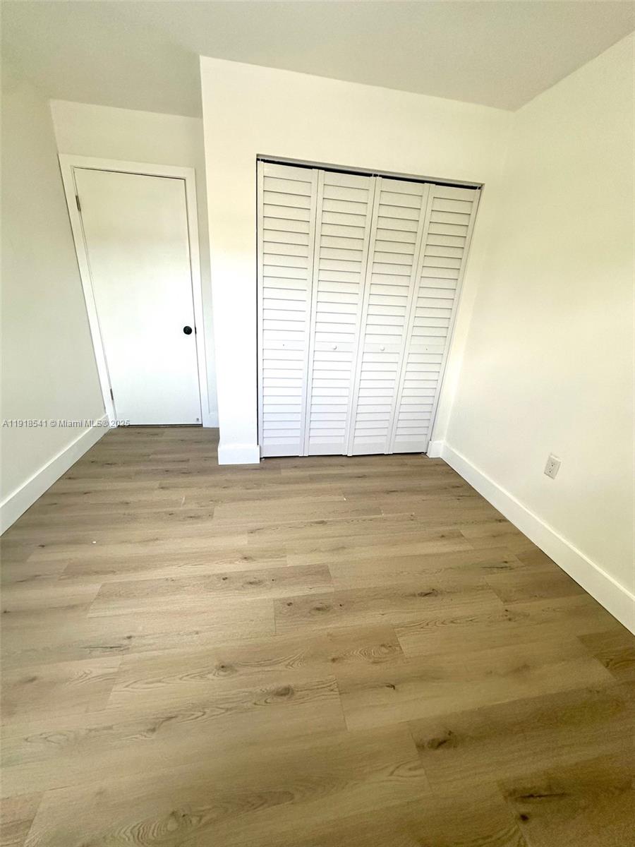 3947 Northwest 207 St Road Miami Gardens, FL 33055 - Photo 18 of 23 an empty room with wooden floor and windows